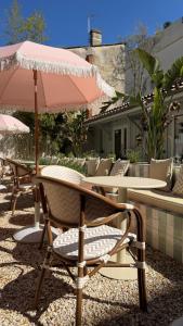 a table and chairs with an umbrella on a patio at Boutique Hôtel Le Clos Huguerie - Bordeaux Centre in Bordeaux