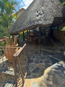 a hut with a bench and a table and chairs at The Rock & Root Guesthouse Self Catering in Nelspruit
