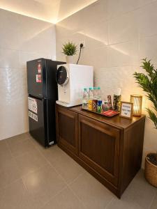 a kitchen with a refrigerator and a counter with a microwave at Eryna Homestay in Nibung Tebal