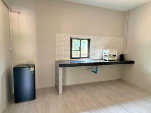 a kitchen with a table and a refrigerator in a room at I mee Lanta Home in Phra Ae beach