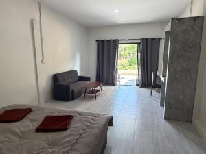 a bedroom with a bed and a couch and a table at I mee Lanta Home in Phra Ae beach