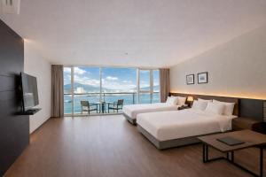 a hotel room with two beds and a view of the ocean at Venezia Hotel and Suite in Yeosu +68 photos