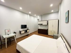 a bedroom with a bed and a desk and a tv at Eco Nest Hotel 6 Đình Ngang in Hanoi