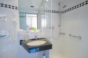 a bathroom with a sink and a shower at Gasthaus Zum Schwan in Oschatz +43 photos