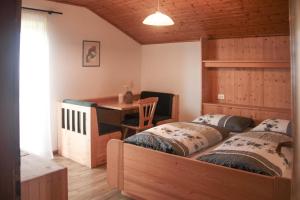 a bedroom with two twin beds and a desk at mösslerhof in Aldino
