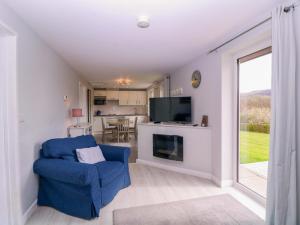 a living room with a blue chair and a fireplace at Sunny Cottage in Brecon