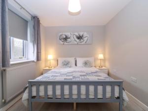 a bedroom with a large bed with two lamps at Sunny Cottage in Brecon