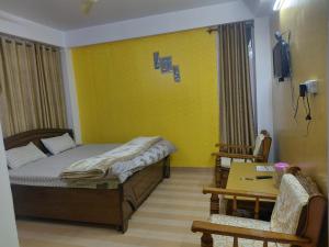 a bedroom with a bed and a table and chairs at Indu Homestay in Shimla +18 photos