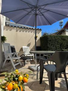 a patio with a table and chairs and an umbrella at Royans Ferienwohnung in Günzburg