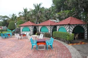 a group of chairs and tables in a patio at Hotel Jeet Paradise in Phaltan