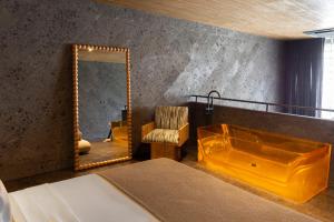 a bedroom with a mirror and a bed and a chair at The Lima Ocean Suites Pererenan in Canggu