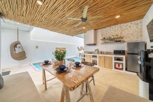 a kitchen with a wooden table in a room at Casa Sud - Secluded Pool Villa in Uluwatu in Uluwatu