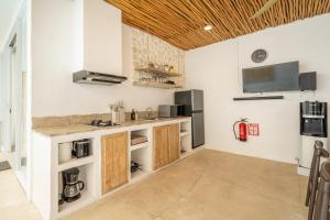 a kitchen with white walls and a wooden ceiling at Casa Sud - Secluded Pool Villa in Uluwatu in Uluwatu +24 photos