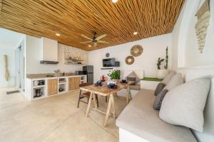 a kitchen and living room with a wooden ceiling at Casa Sud - Secluded Pool Villa in Uluwatu in Uluwatu