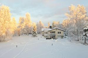 a house in the middle of a snow covered field at Aurora Sky Villa in Rovaniemi