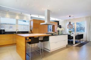 a kitchen with a large island with bar stools at Aurora Sky Villa in Rovaniemi