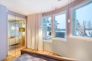 a bedroom with large windows and a room with a bed at Aurora Sky Villa in Rovaniemi