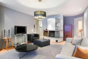 a living room with a couch and a tv at Aurora Sky Villa in Rovaniemi