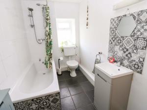a bathroom with a toilet and a tub and a sink at The Hayloft in Ripon +20 photos