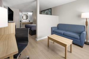 a living room with a blue couch and a table at Super 8 by Wyndham Ellenton Bradenton Area in Ellenton