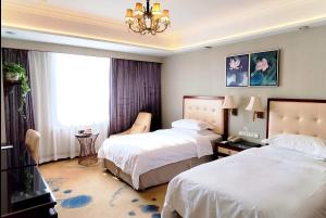 a hotel room with two beds and a chandelier at Ramada Plaza Tianlu Hotel in Wuhan +43 photos