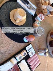 a table topped with a plate with a cup of coffee at Chambres d'hôtes "Chez Lyly et Juju" Piscine&Sauna Parking Gratuit in Angers