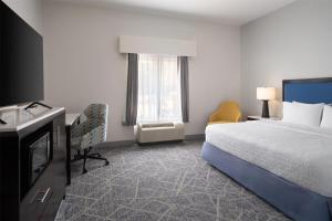 a hotel room with a bed and a desk and a television at Hampton Inn Augusta Fort Eisenhower in Augusta +12 photos