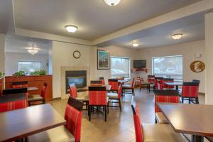 a restaurant with tables and chairs and a fireplace at Comfort Inn & Suites Salem Northeast in Salem
