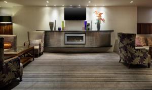 a lobby with a fireplace in a hotel room at DoubleTree by Hilton Stratford-upon-Avon, United Kingdom in Stratford-upon-Avon