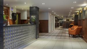 a lobby of a hotel with a bar and chairs at DoubleTree by Hilton Stratford-upon-Avon, United Kingdom in Stratford-upon-Avon