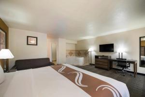 a hotel room with a large bed and a desk at Quality Inn & Suites Lufkin in Lufkin