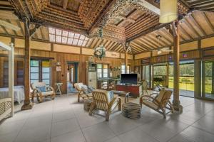 a large living room with chairs and a television at Rancho Crescent Head in Crescent Head
