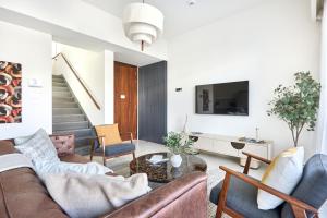 a living room with a couch and a tv at Frank Porter - Nara, The Valley in Dubai
