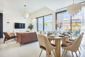 a living room with a table with chairs and a couch at Frank Porter - Nara, The Valley in Dubai