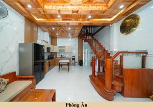 a living room with a kitchen and a staircase in a room at Green Homestay in Danang