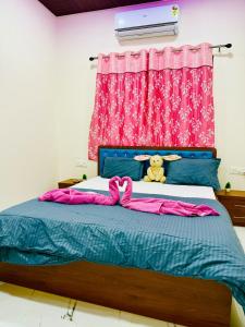 a bedroom with a blue bed with a pink curtain at Kohinoor villa in Lonavala +4 photos