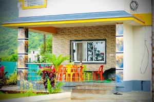 a small house with a table and chairs on the porch at Kohinoor villa in Lonavala