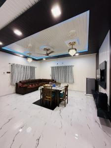 a living room with a table and a couch at Kohinoor villa in Lonavala