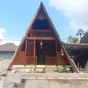 a house with a wooden roof at Umah Pororo in Karangasem