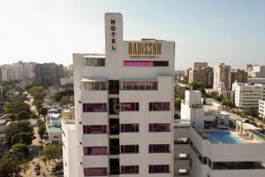 a tall white building with a sign on top of it at Radisson Diamond Barranquilla in Barranquilla