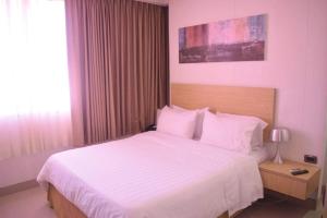 a bedroom with a large bed with white sheets at Radisson Diamond Barranquilla in Barranquilla +158 photos