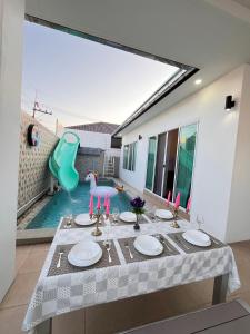 a dining room with a table and a swimming pool at Cozy Poolvilla Pattaya in Bang Lamung