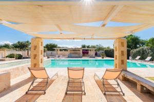 a patio with chairs and a swimming pool at Masseria Capricella in Fasano
