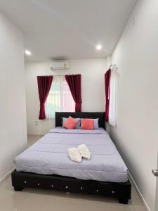 a bedroom with a bed with two towels on it at Cozy Poolvilla Pattaya in Bang Lamung