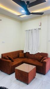 a living room with a brown couch and a coffee table at Vishwa Adithya Service Apts in Venkatāpur