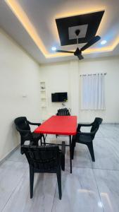 a dining room with a red table and chairs at Vishwa Adithya Service Apts in Venkatāpur