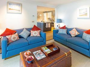 ein Wohnzimmer mit blauen Sofas und einem Couchtisch in der Unterkunft Tarn End in Brampton