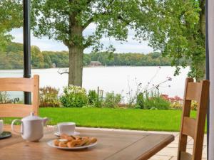 Ein Tisch mit einem Teller Brot und Blick auf einen See in der Unterkunft Tarn End in Brampton + 14 Fotos