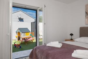 a bedroom with a sliding glass door with a play house at Casa Mia in Danilo Biranj +67 photos