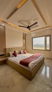 a bedroom with a large bed with a ceiling fan at HOTEL RR Grand in Varanasi